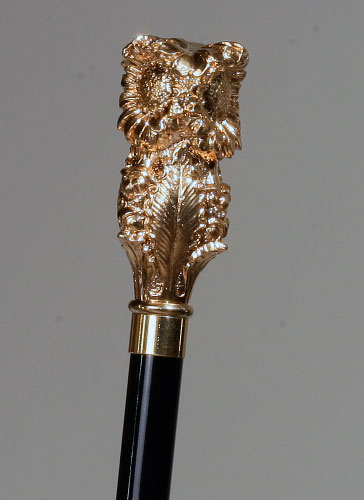 Bastón negro con empuñadura dorada.